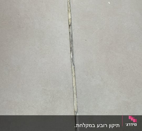 רצפת אריחים עם רובה פגומה סביב ניקוז
